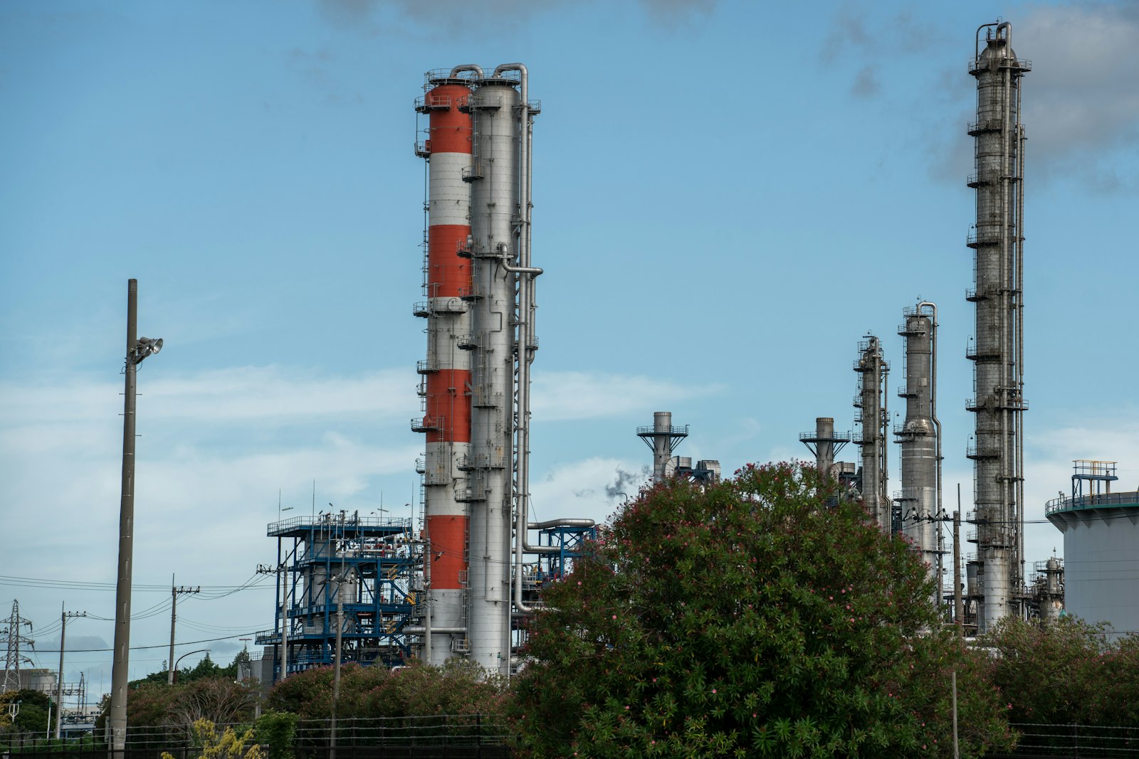 Oil refinery towers against the sky &mdash; pricing oil in dollars became the anchor of the petrodollar system